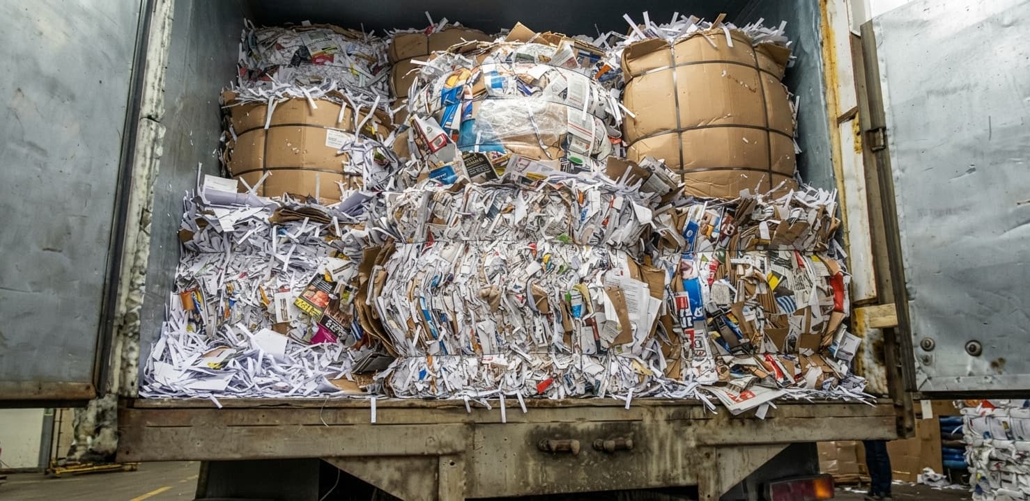 Bales of shredded paper and recyclable material loaded in a junk removal truck