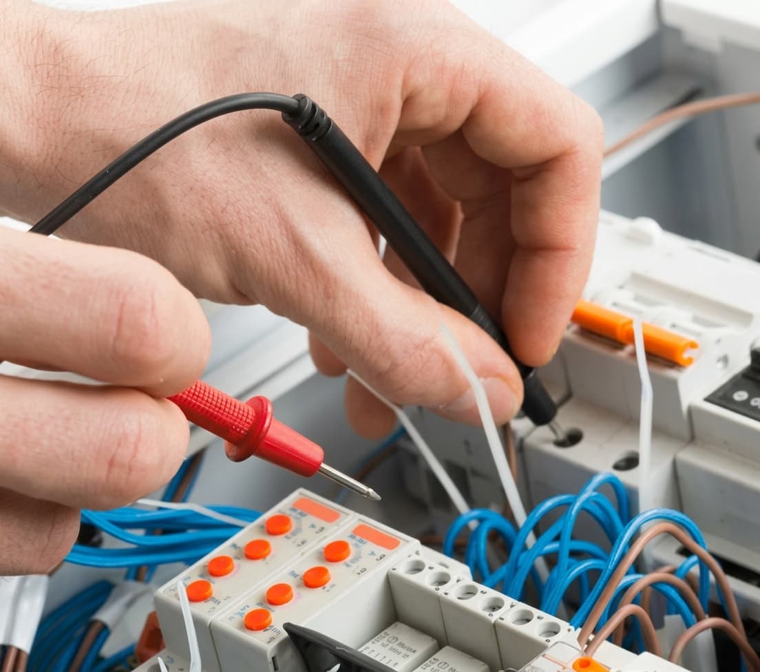 Close-up of an electrician using a multimeter to test wiring
